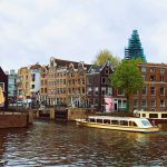 عکس رودخانه ای در آمستردام که در آن قایق است.